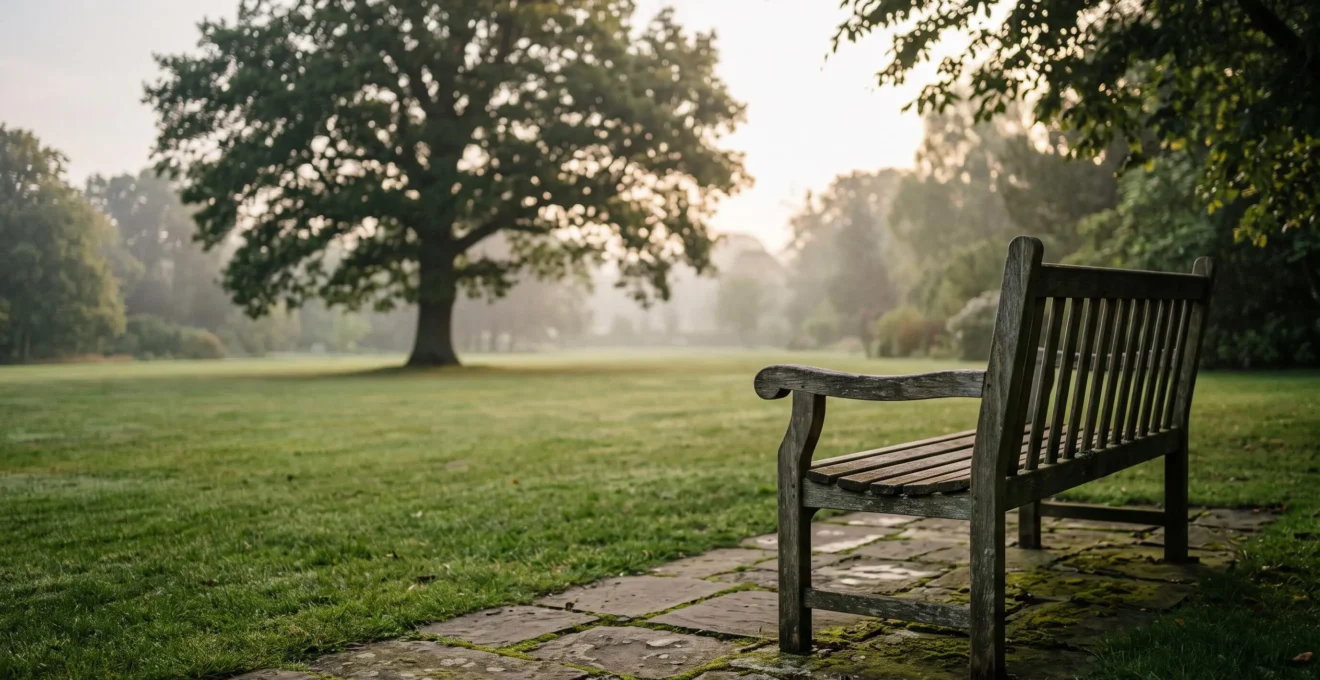 Un banc en bois vide face à un jardin paisible au lever du soleil, symbolisant la reflexion serene autour de la preparation d'une ceremonie funeraire personnalisee